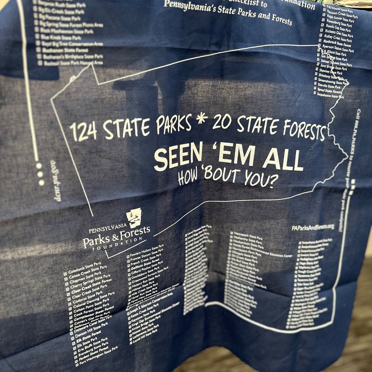 A tablecloth with text reading: "124 States Parks. 20 State Forests. Seen 'Em All. How 'Bout You?"