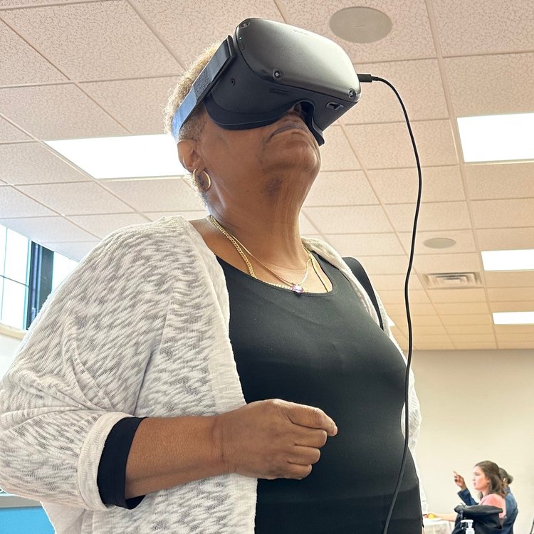 Two older Black women use virtual reality tech to look at historic photos of the Hill District.