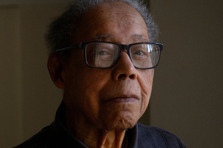 A close-up of an older Black man with eyeglasses.