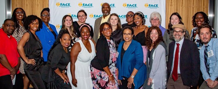 20 people of all races, ages and genders pose in front of a step and repeat banner that says "Macedonia FACE."