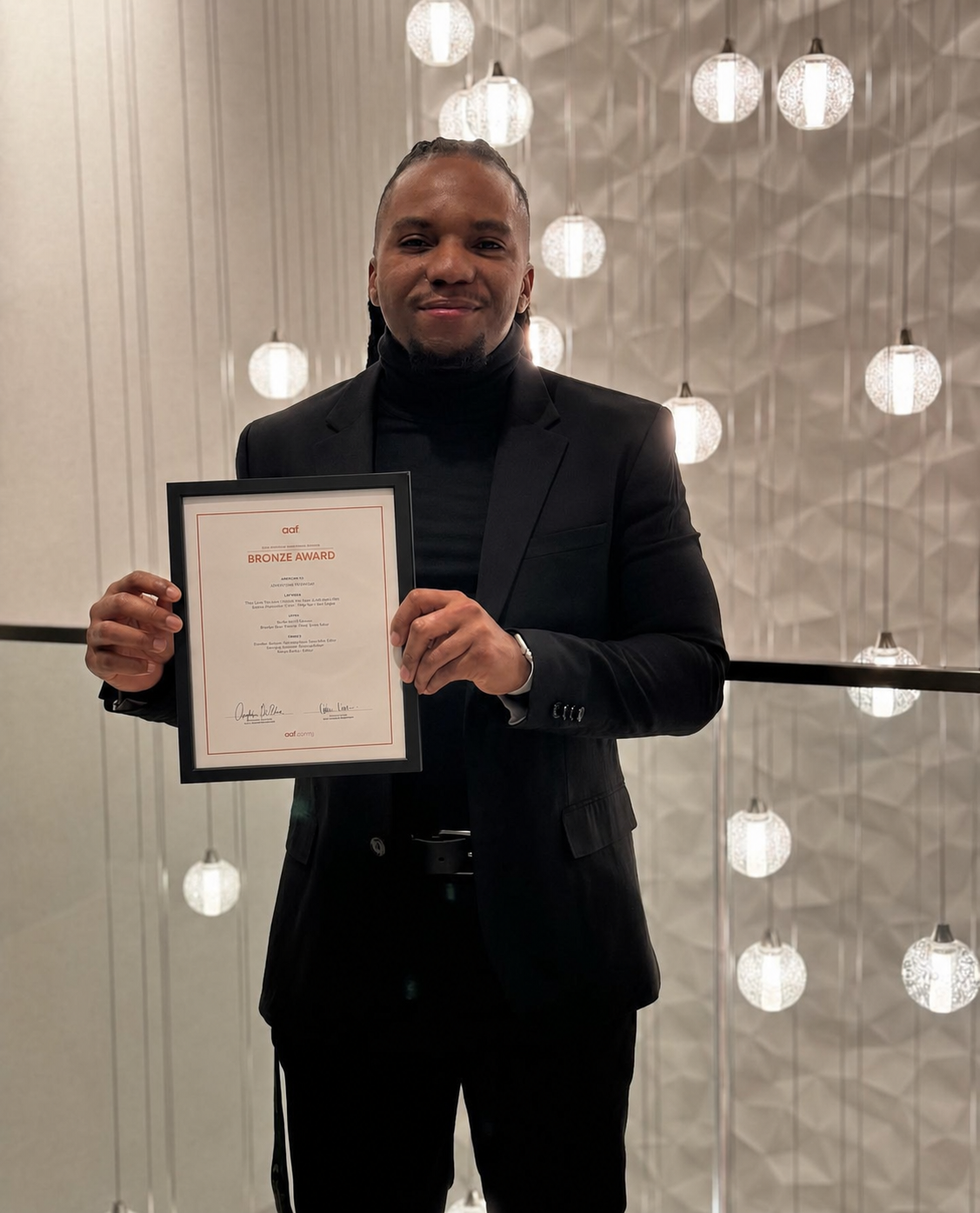 Portrait of Brandon Drain holding an AAF award