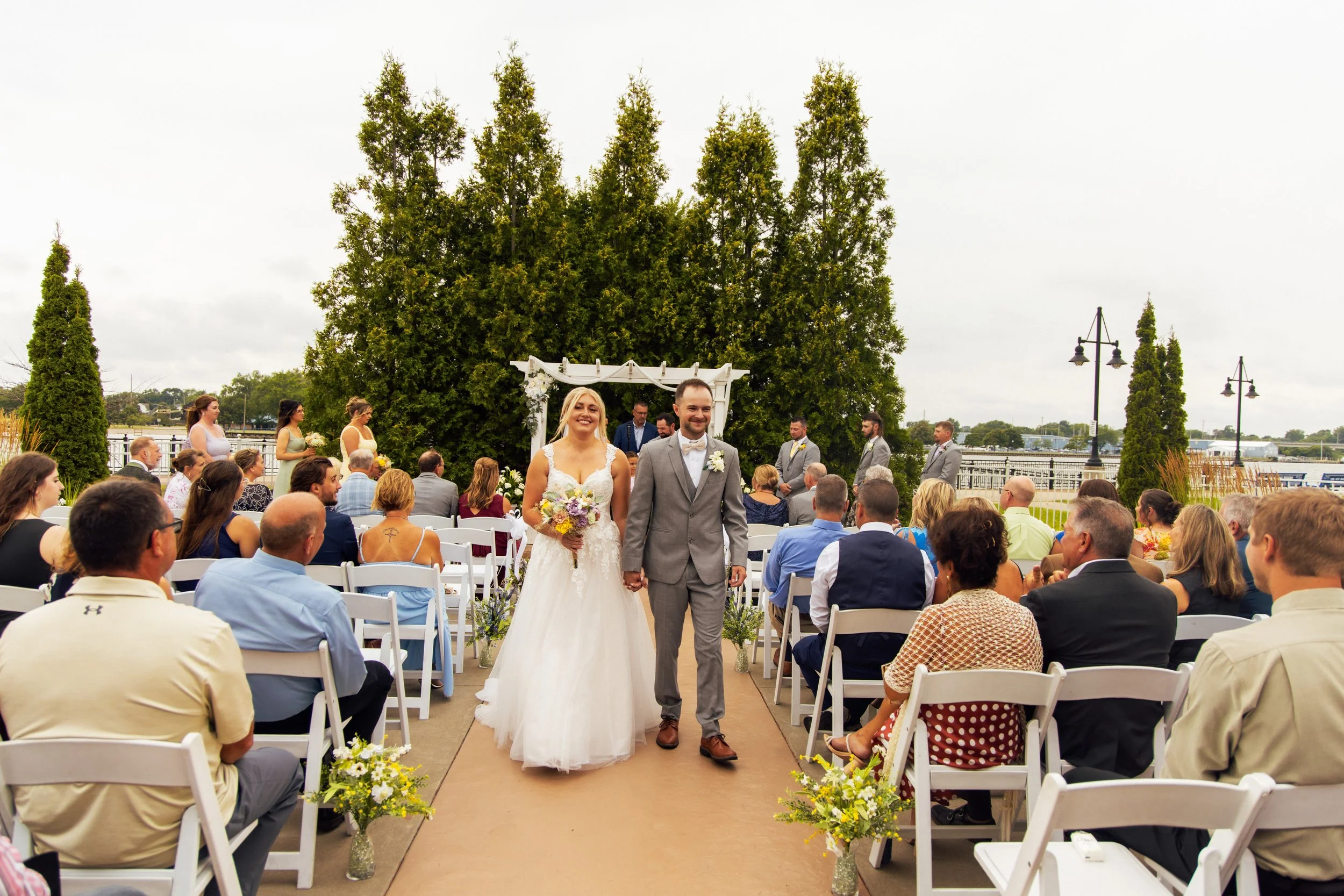 Noah and Jenna walking hand in hand after their wedding ceremony in Bay City, Michigan