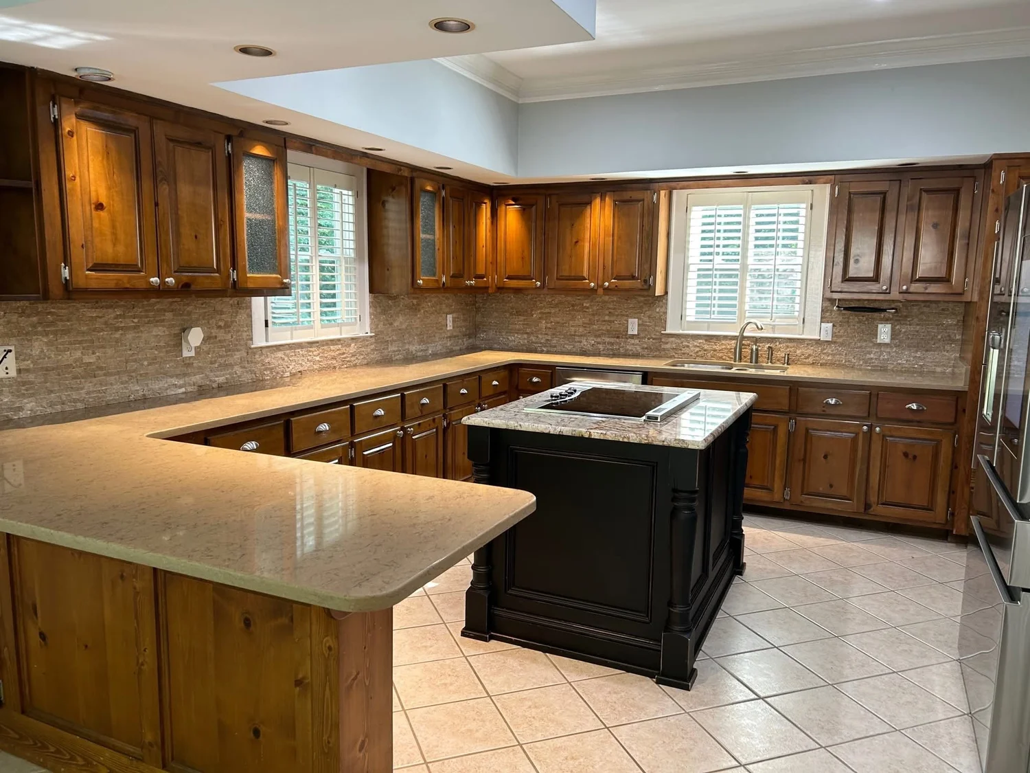 Roswell kitchen before cabinet painting, with original stained knotty pine cabinets and a dark island