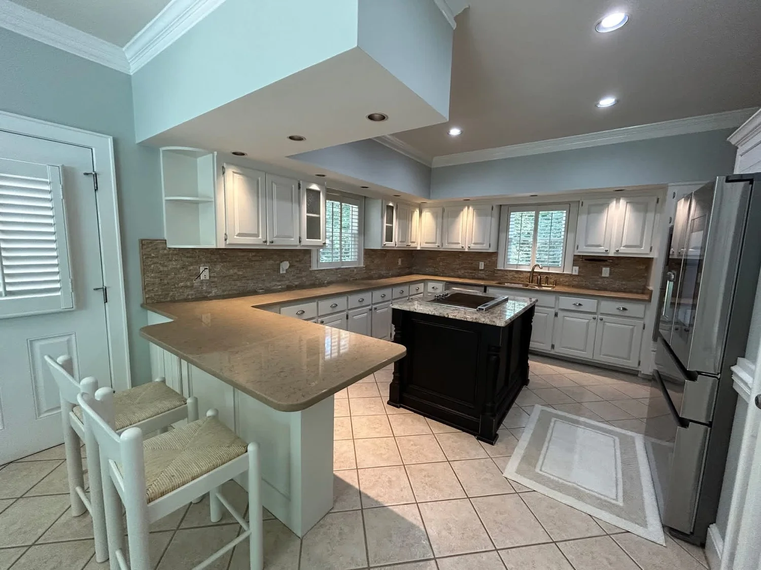 The same Roswell kitchen after cabinet painting, with cabinets and peninsula finished in white enamel