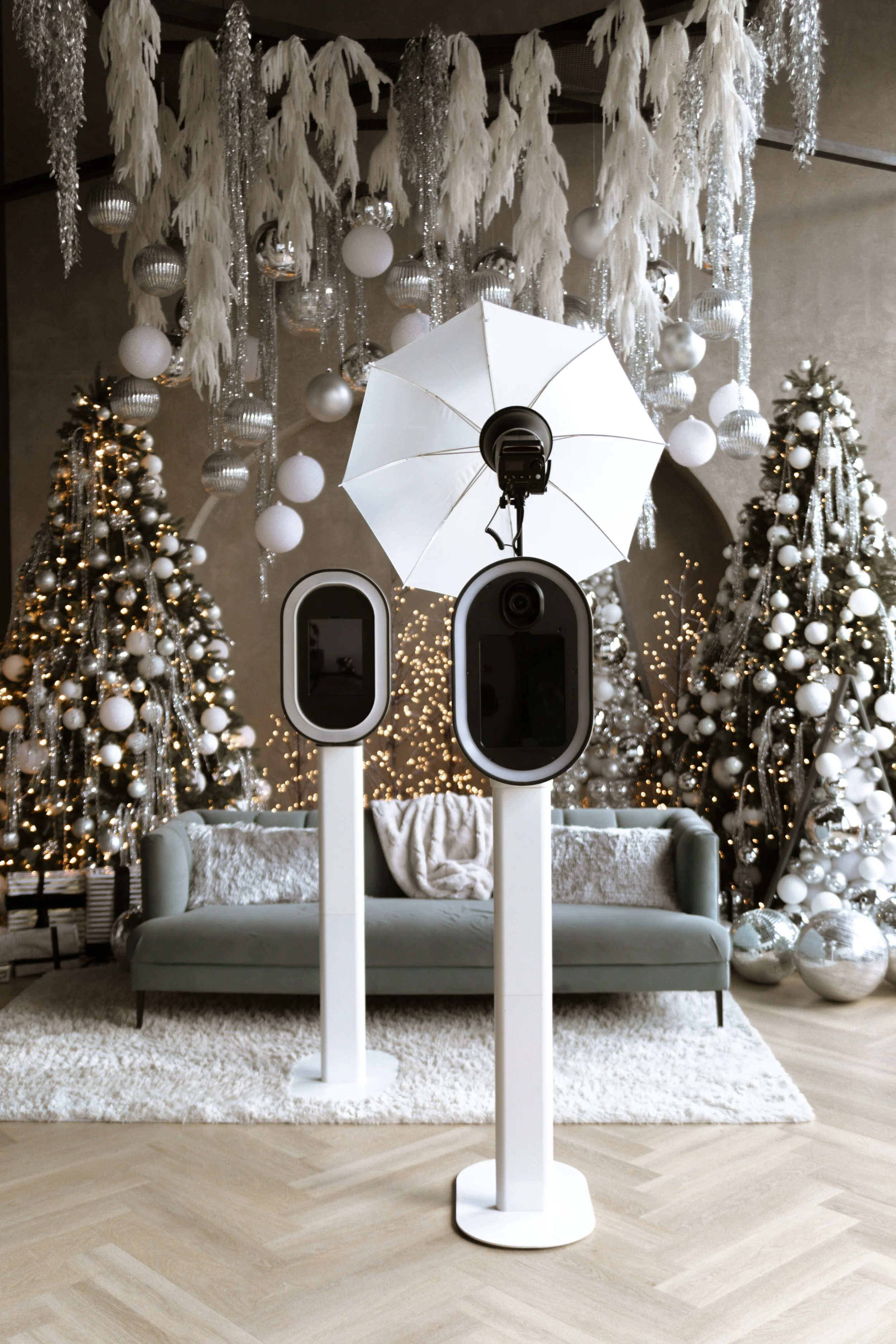 Modern photo booths arranged in a festive room with Christmas trees