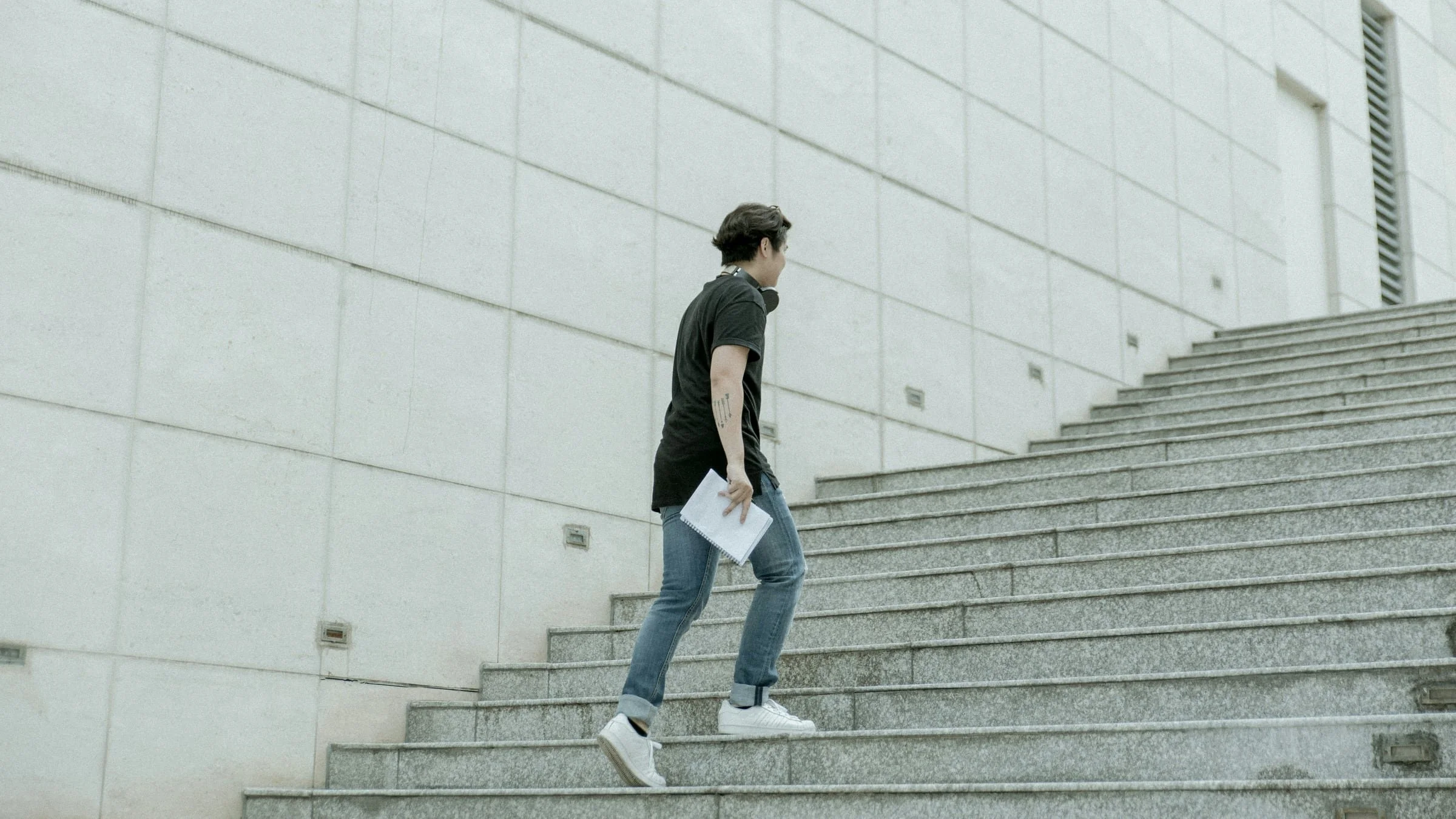 Adult walks up an outdoor staircase, illustrating the strength demand of steps