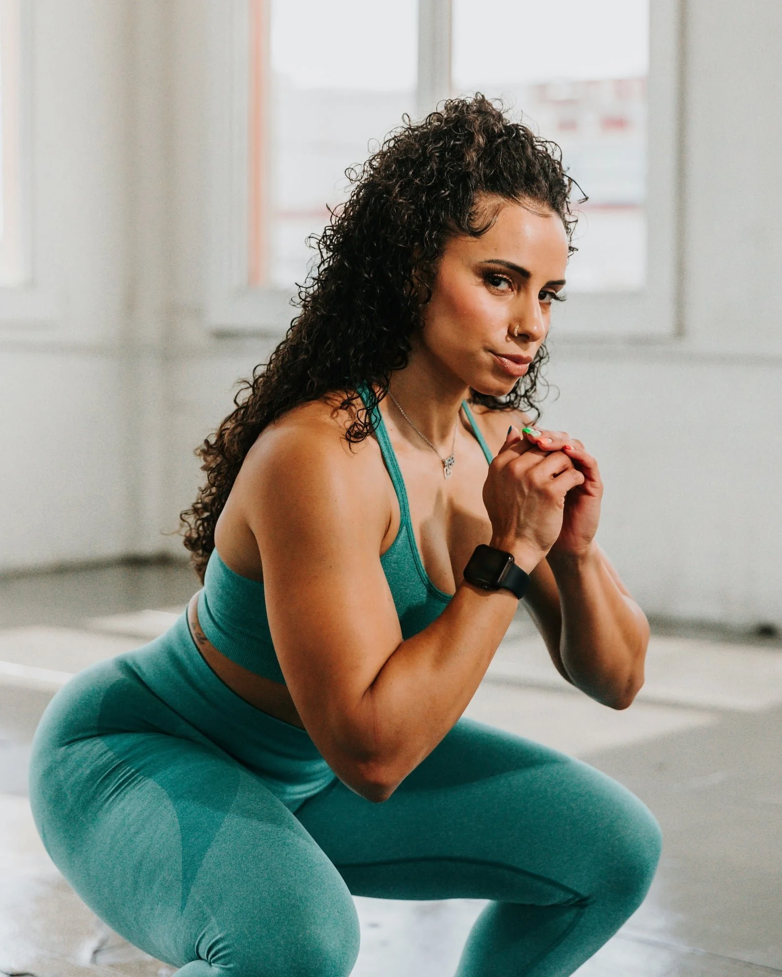 Woman holds a controlled squat during lower-body strength training