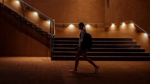 Person walks up a brightly lit staircase