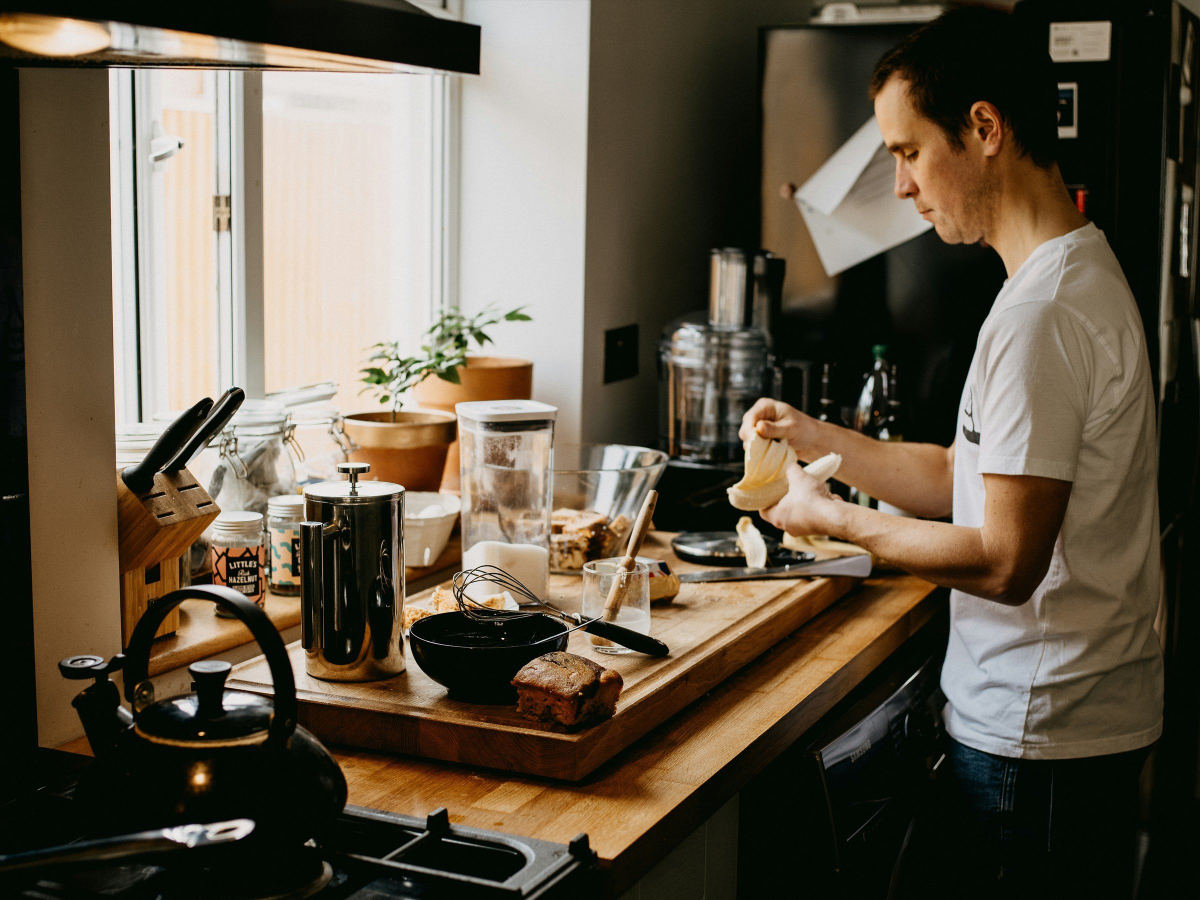 Person peeling a banana at a kitchen counter.