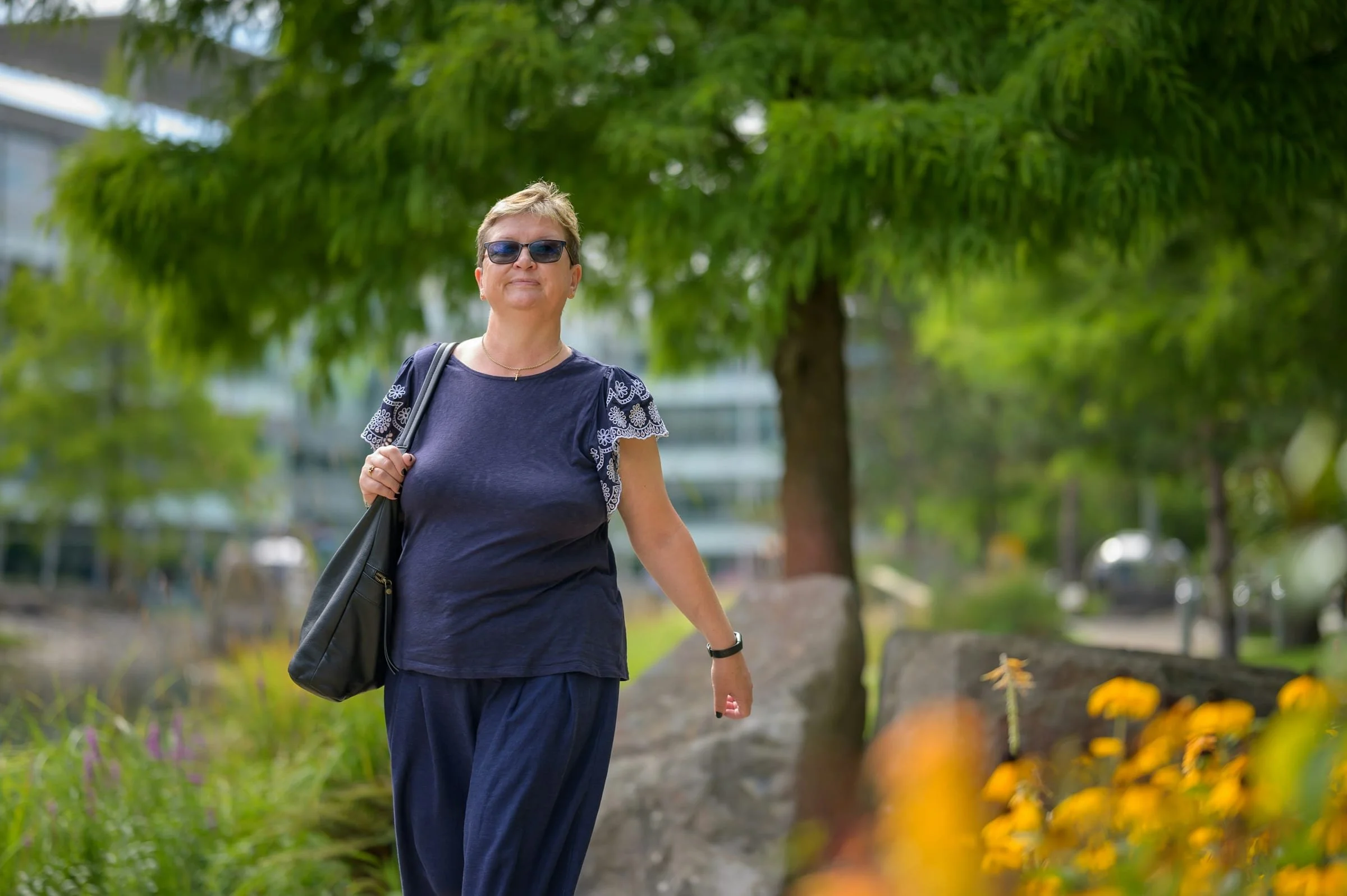 Older adult walks along a paved park path