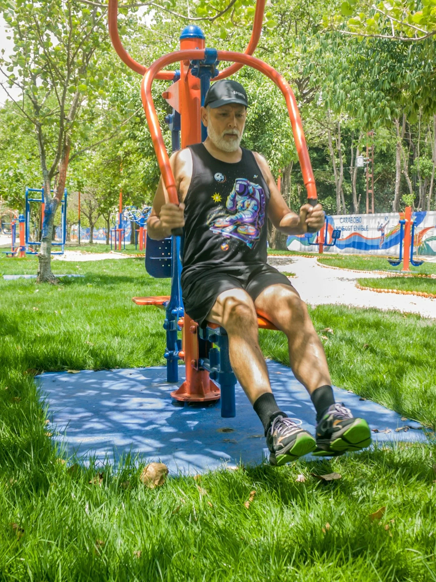 Older man using a chest press machine at an outdoor gym.