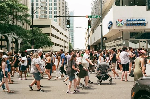 People walking through a sunny outdoor festival, used as an illustrative crowd scene