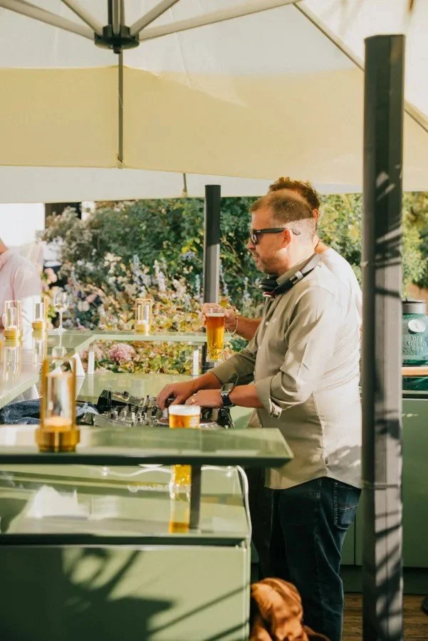 A guest pouring a drink at the counter under a parasol