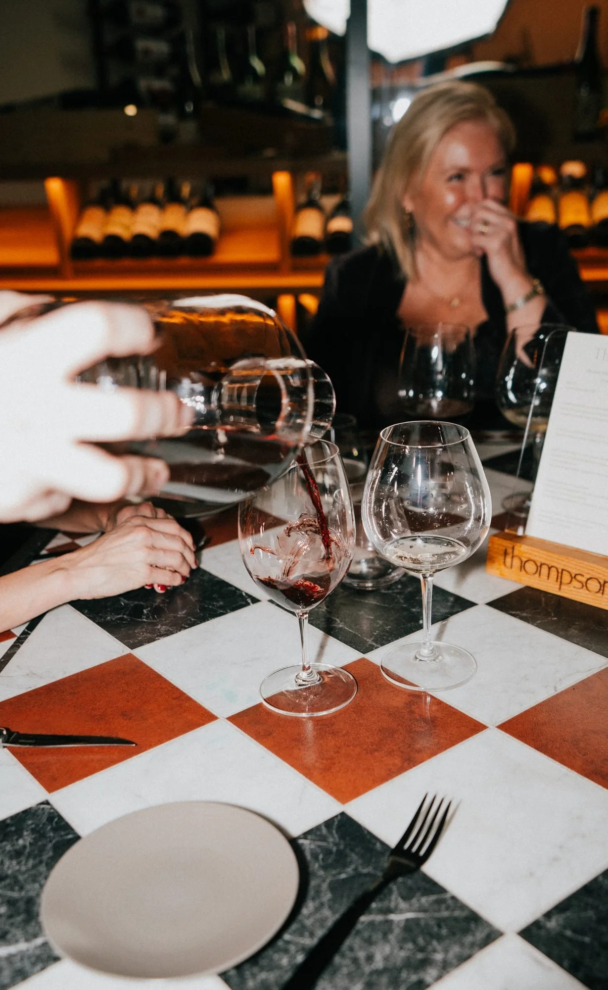 Red wine poured from a decanter at a table at Thompson’s