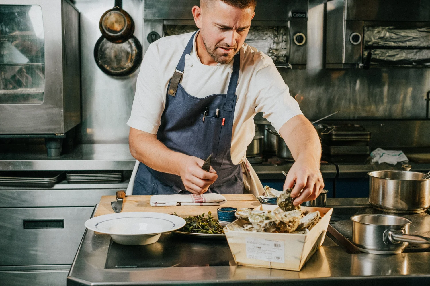 Chef Robert Thompson MBE opening oysters in the RT Café Grill kitchen