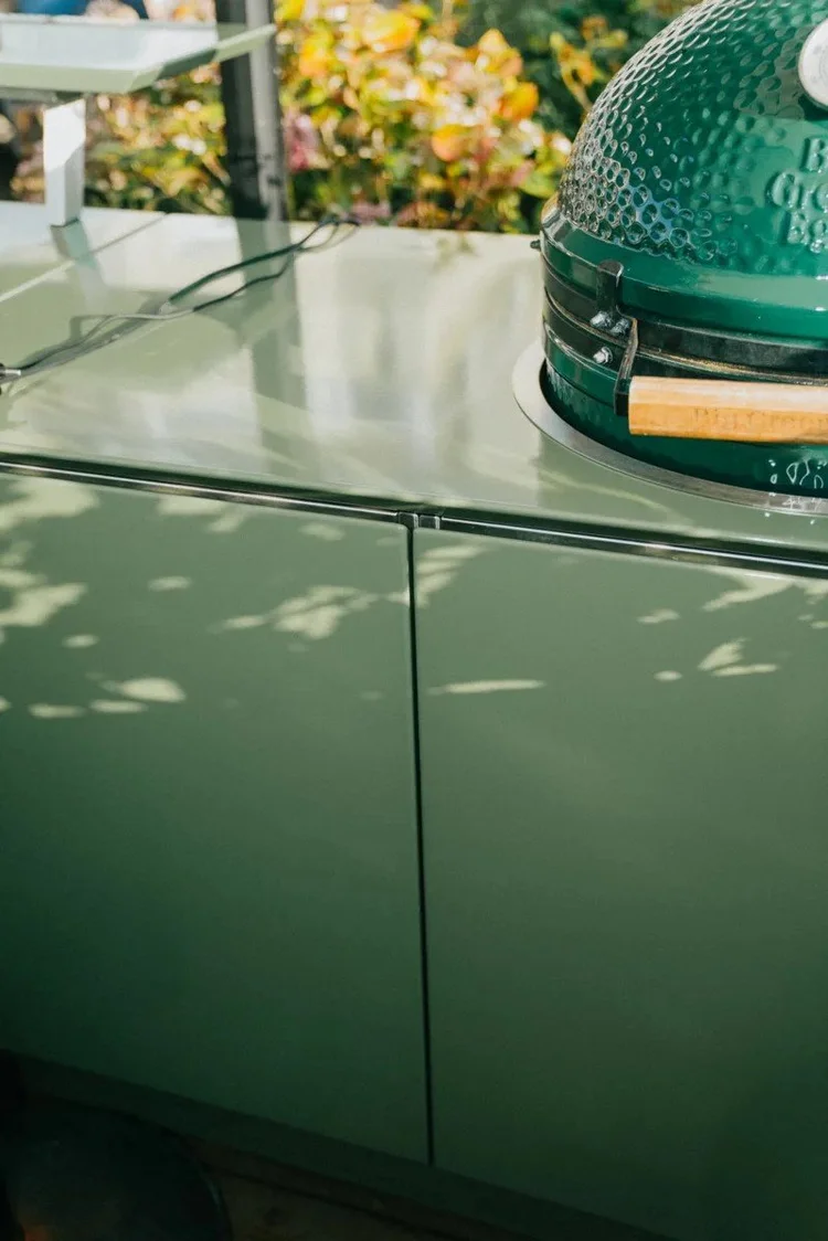 The sage green Vlaze outdoor kitchen with a ceramic grill set into the counter
