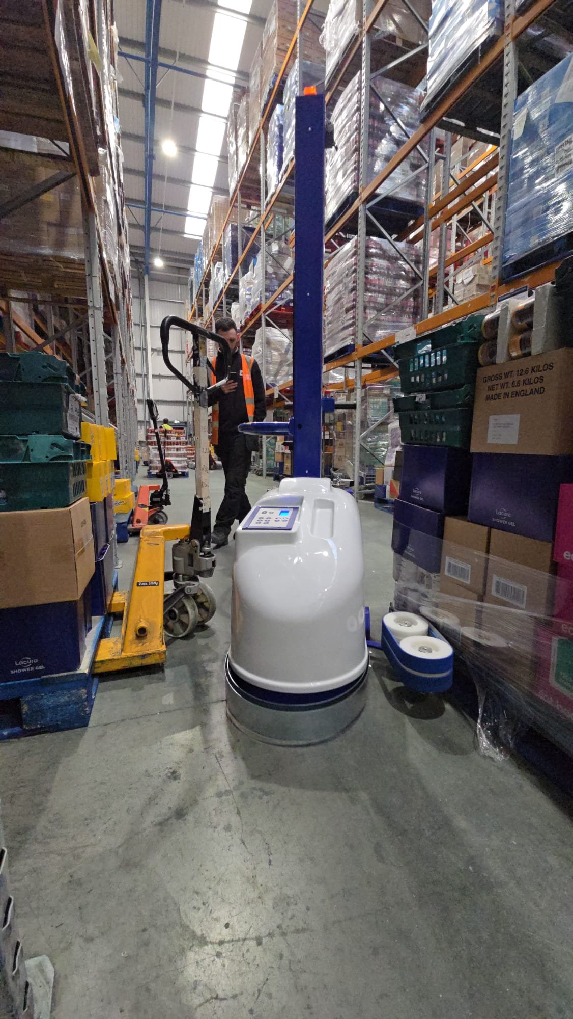 ROBi Mini robot pallet wrapper operating in a narrow warehouse aisle