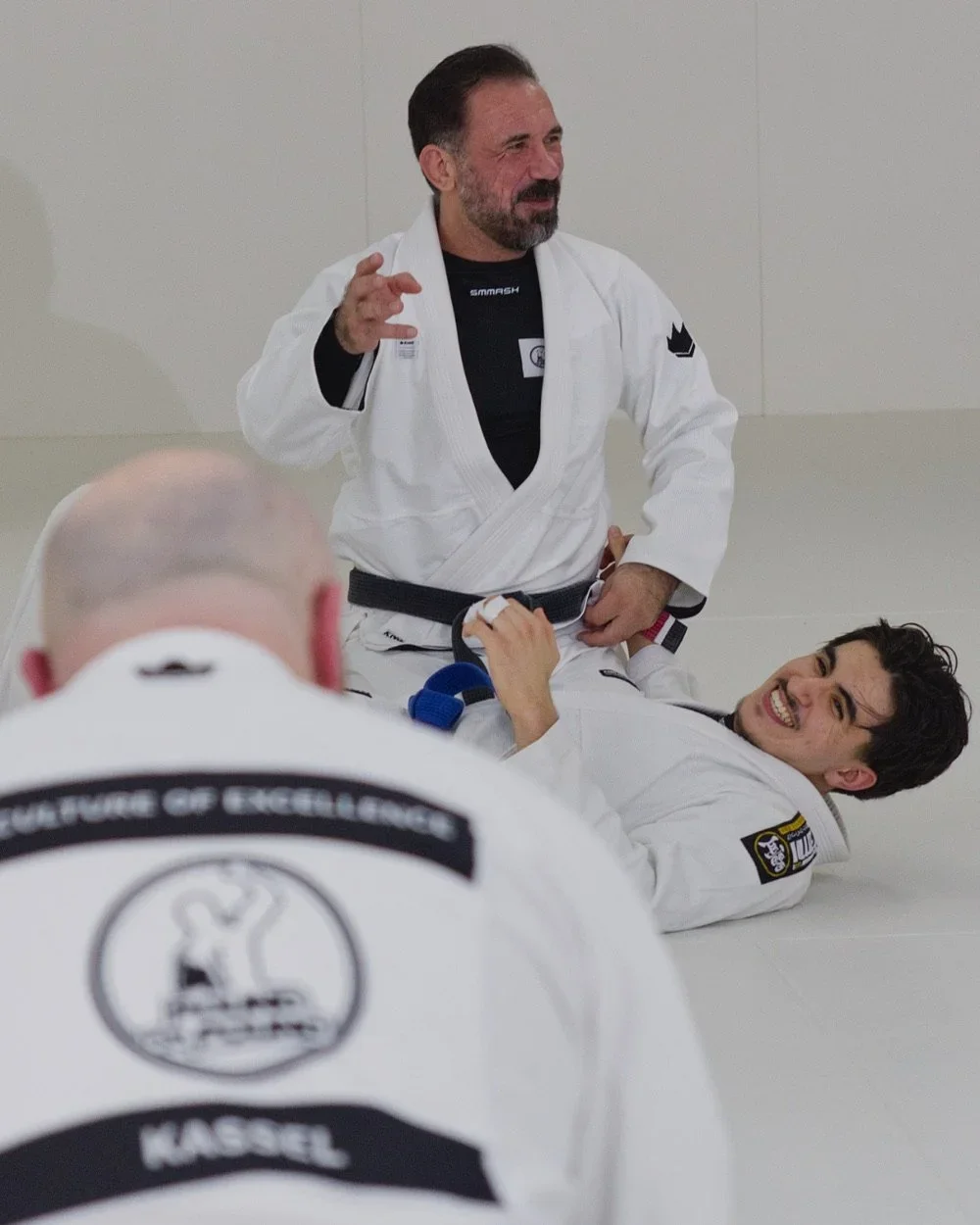 Murat erklärt im Gi eine Technik vor seiner Trainingsgruppe bei Pound For Pound