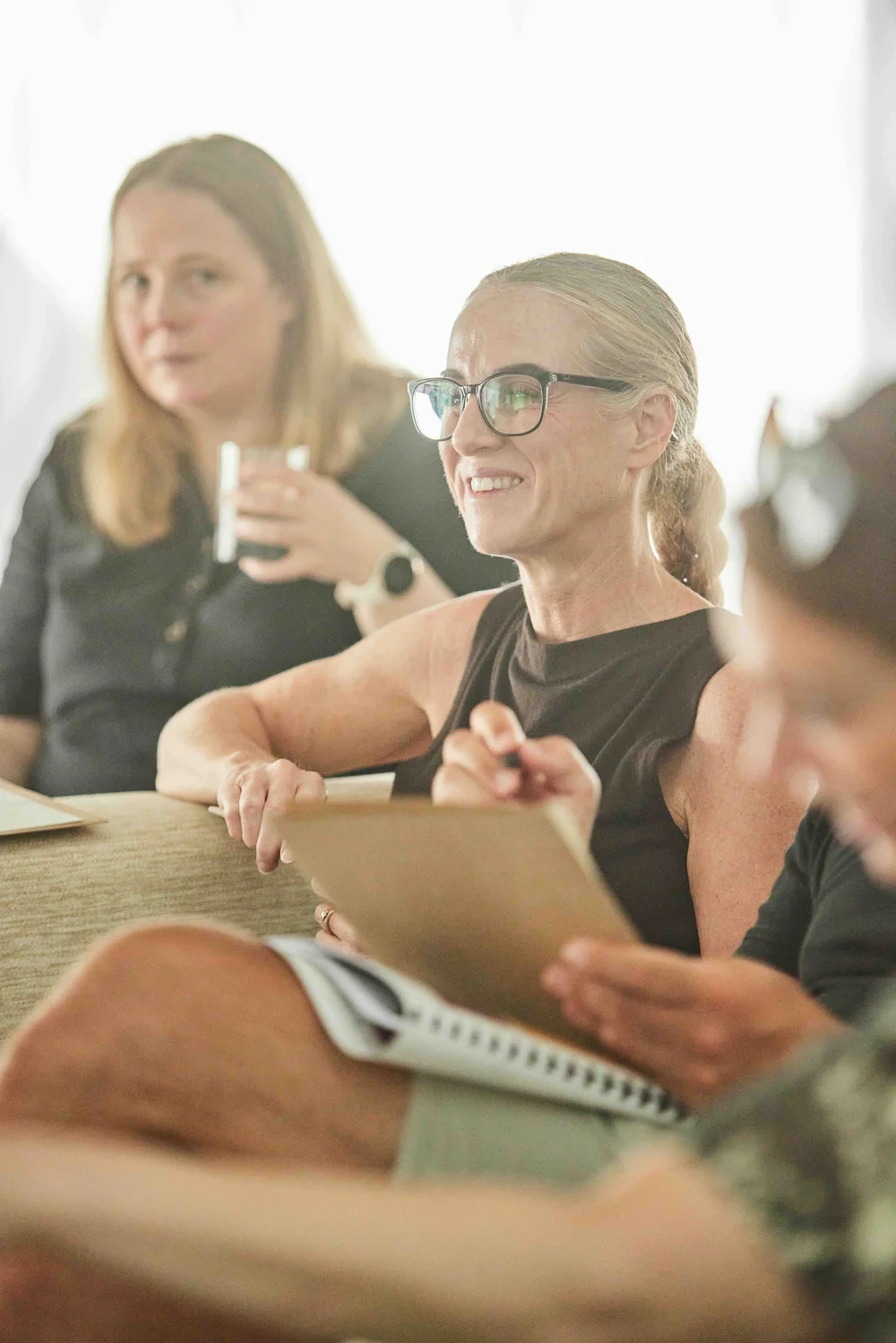 ADHD coaches smiling together around a table at a Gold Mind training session