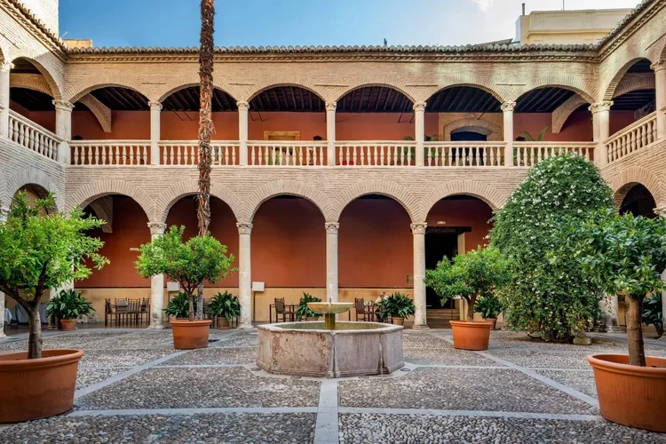 A courtyard with orange trees and arches in Granada