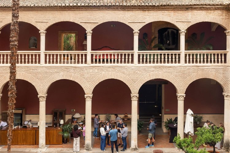 People gathering in an arcaded courtyard in Granada