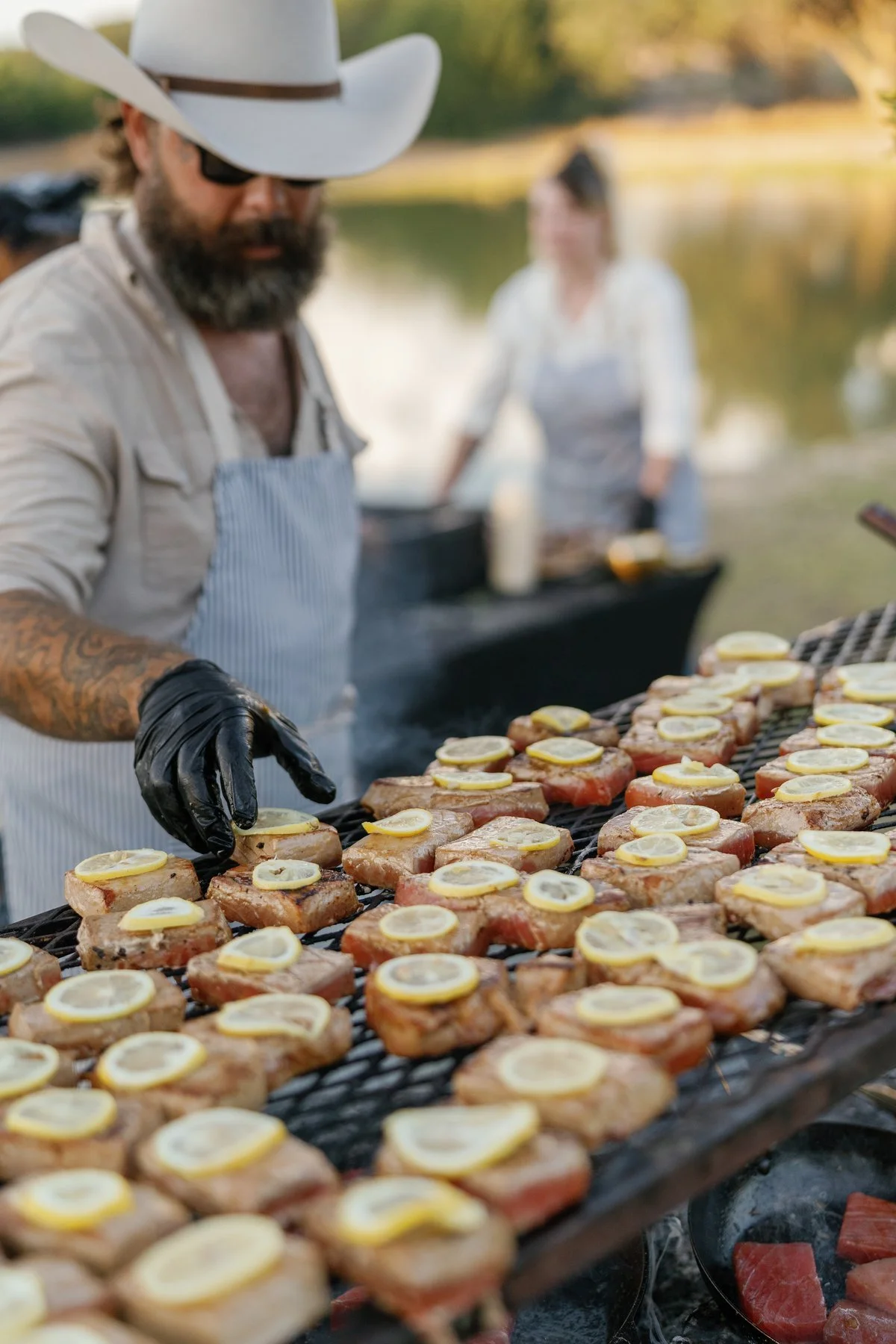 Chef Mike working at the outdoor grill beside the pond.