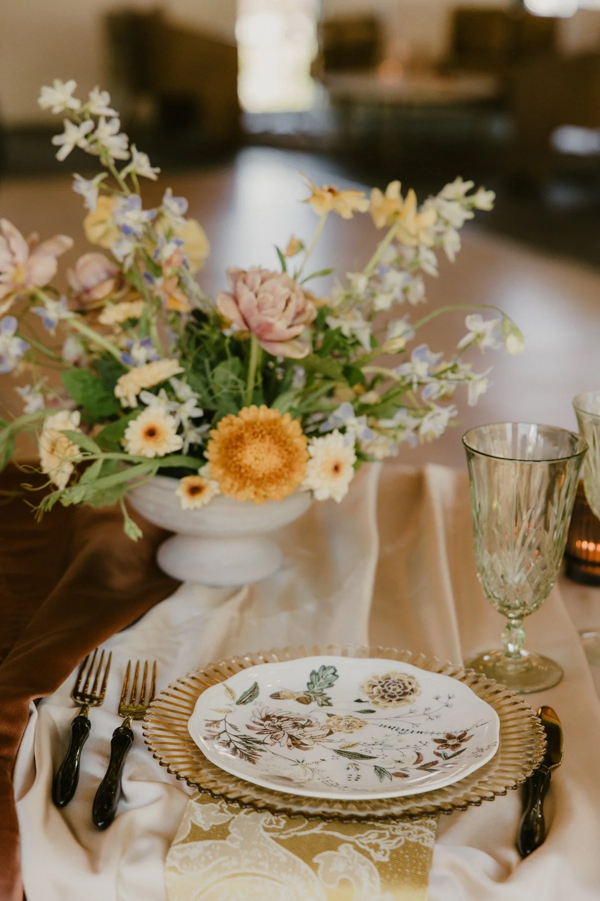 A floral arrangement, patterned plate, and glassware at Springdale Station.