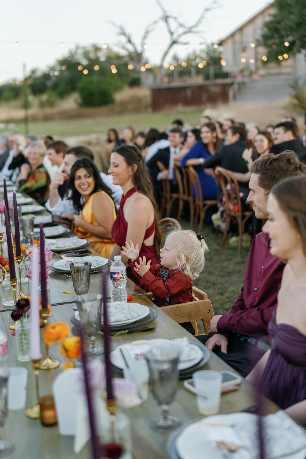Wedding guests seated together at the outdoor dinner table.