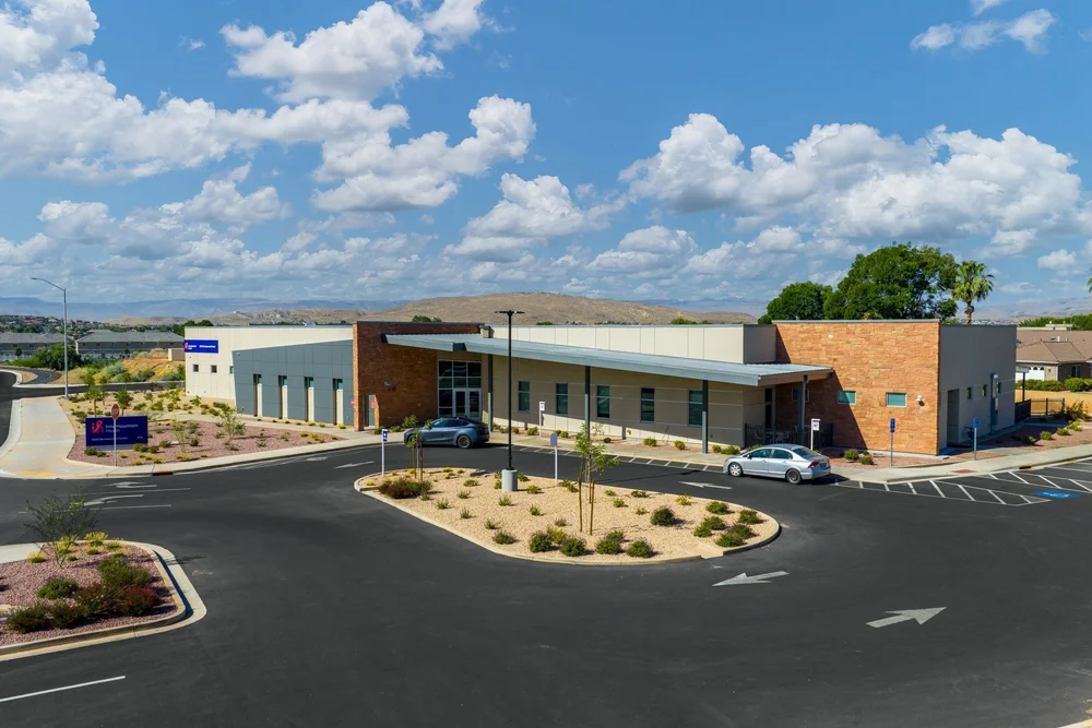 Intermountain Child Development Center exterior beneath a cloud-filled blue sky.