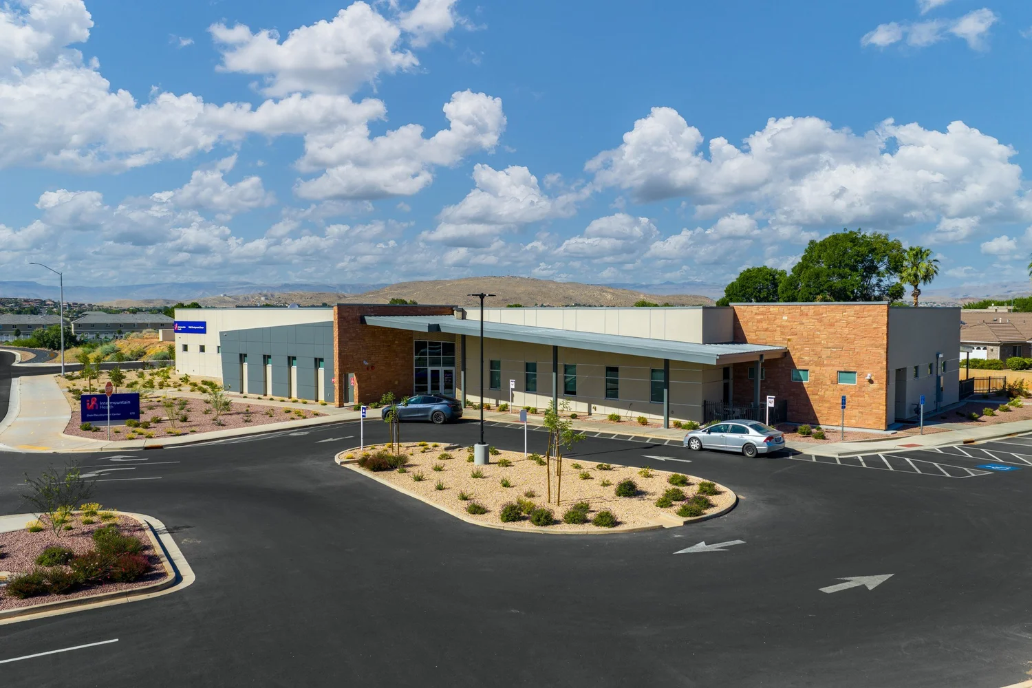 Intermountain Child Development Center exterior beneath a cloud-filled blue sky.