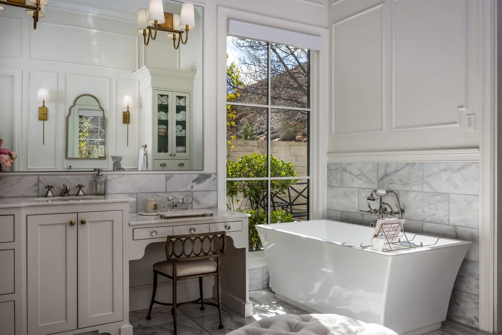 Light-filled bathroom with white cabinetry and a freestanding bathtub