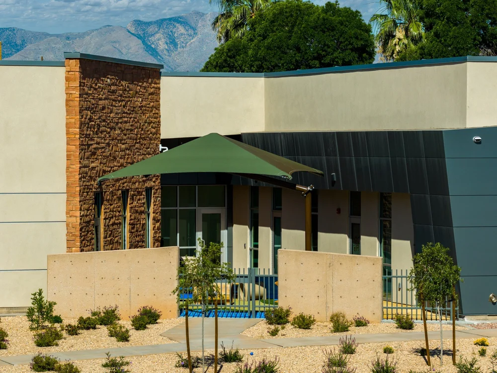 Shaded outdoor area beside the stone and blue-gray exterior walls.