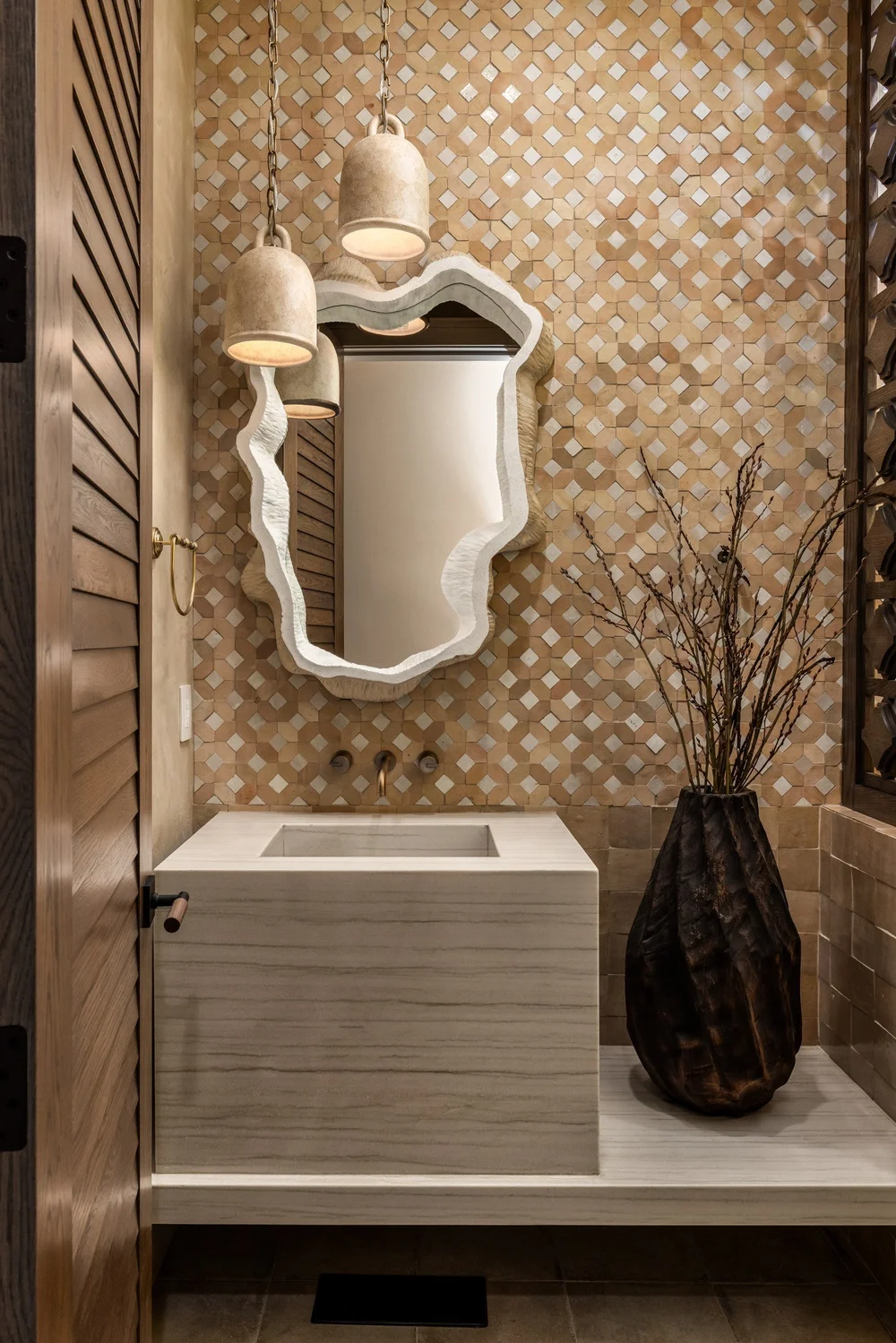 Powder room with patterned wall tile and sculpted mirror