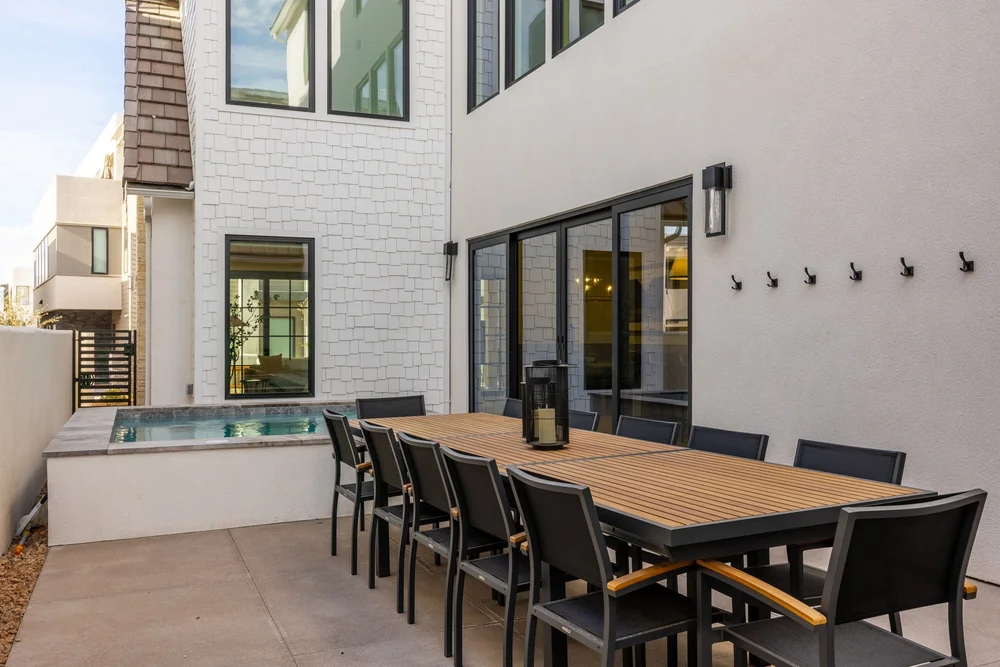 Outdoor dining table and spa on a private patio at Lula Bay