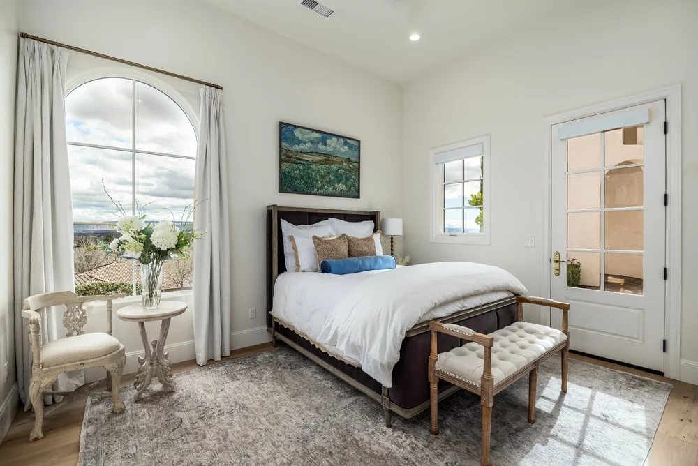 Bedroom with an arched window and upholstered bed
