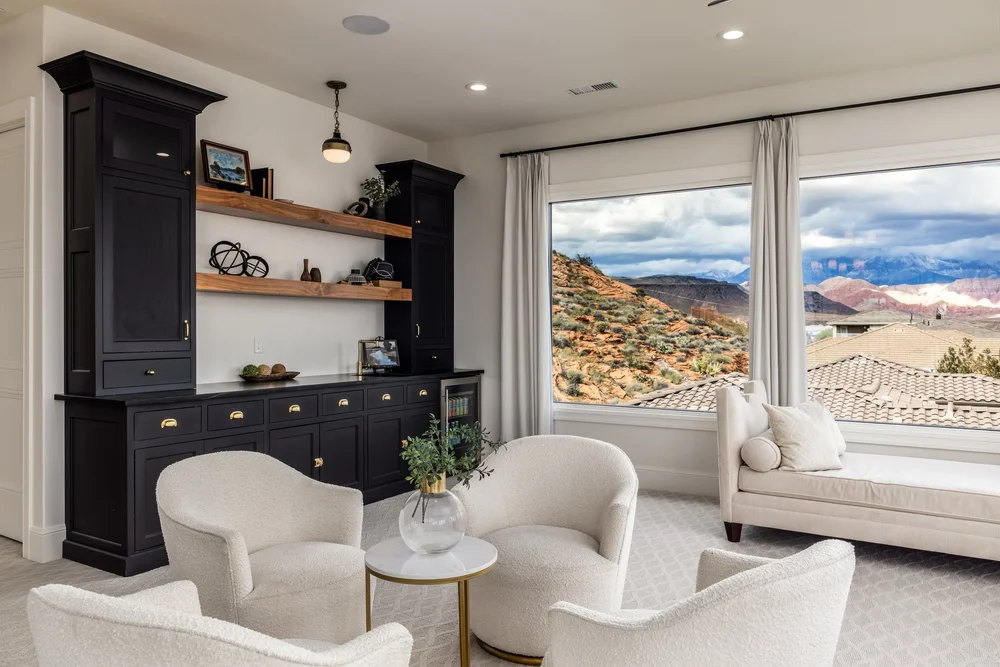 Sitting room with dark built-in cabinetry and windows overlooking red-rock hills at the Sunset property
