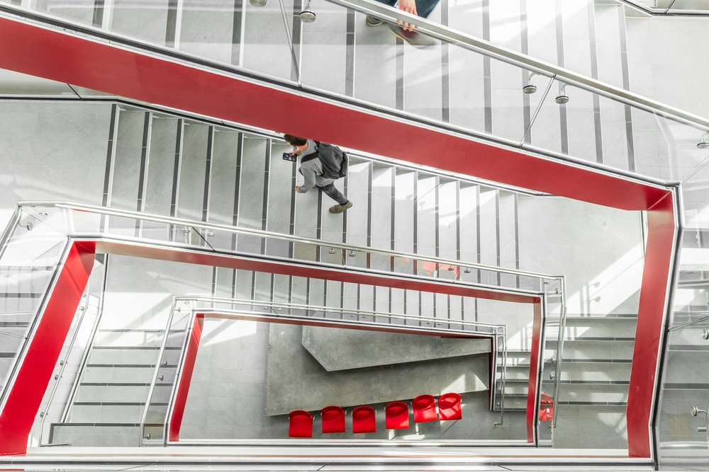 Red-edged stair flights and glass balustrades inside the Utah Tech SET building.