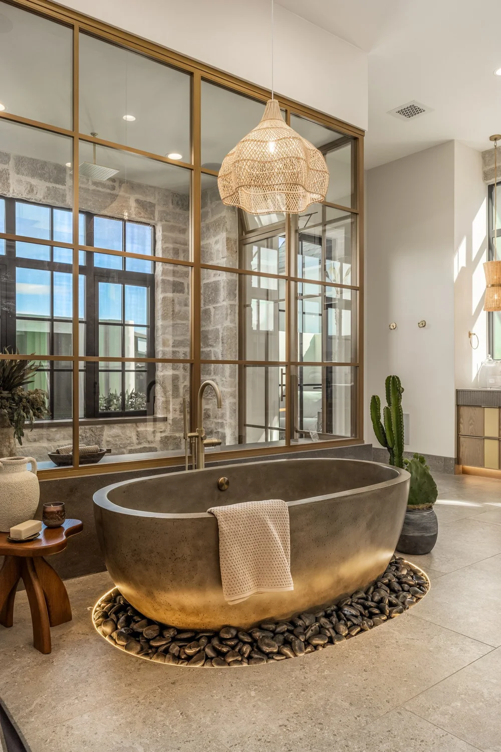 Freestanding bathtub beside an interior glass partition