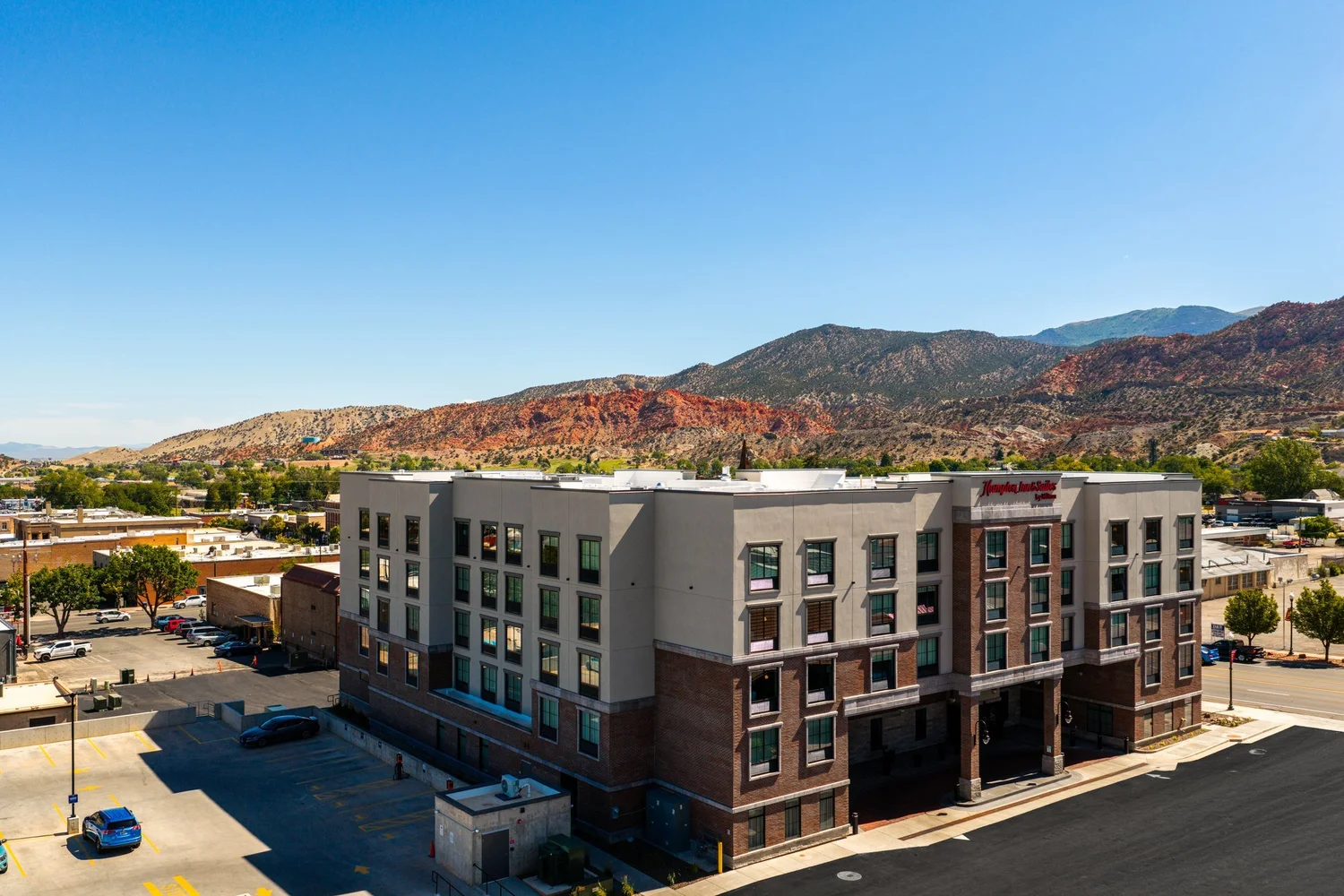 Elevated view of Hampton Inn & Suites with red-rock hills across the Cedar City landscape.