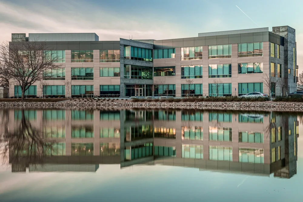 Jacobsen headquarters reflected in still water at dusk.