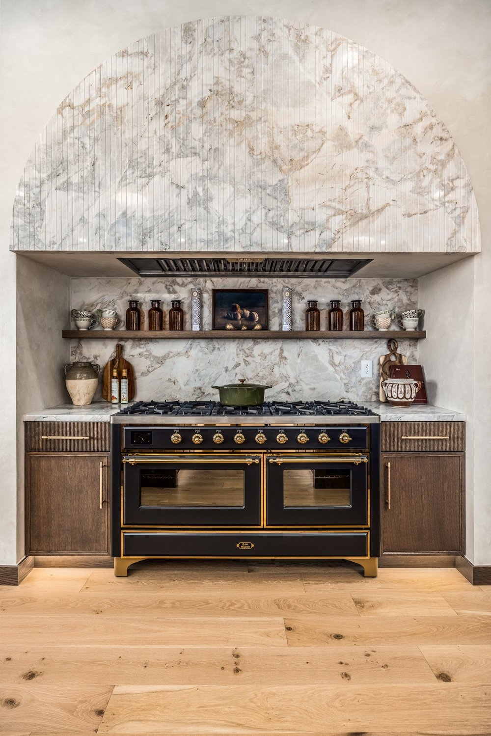 Black-and-gold range beneath a sculpted stone hood
