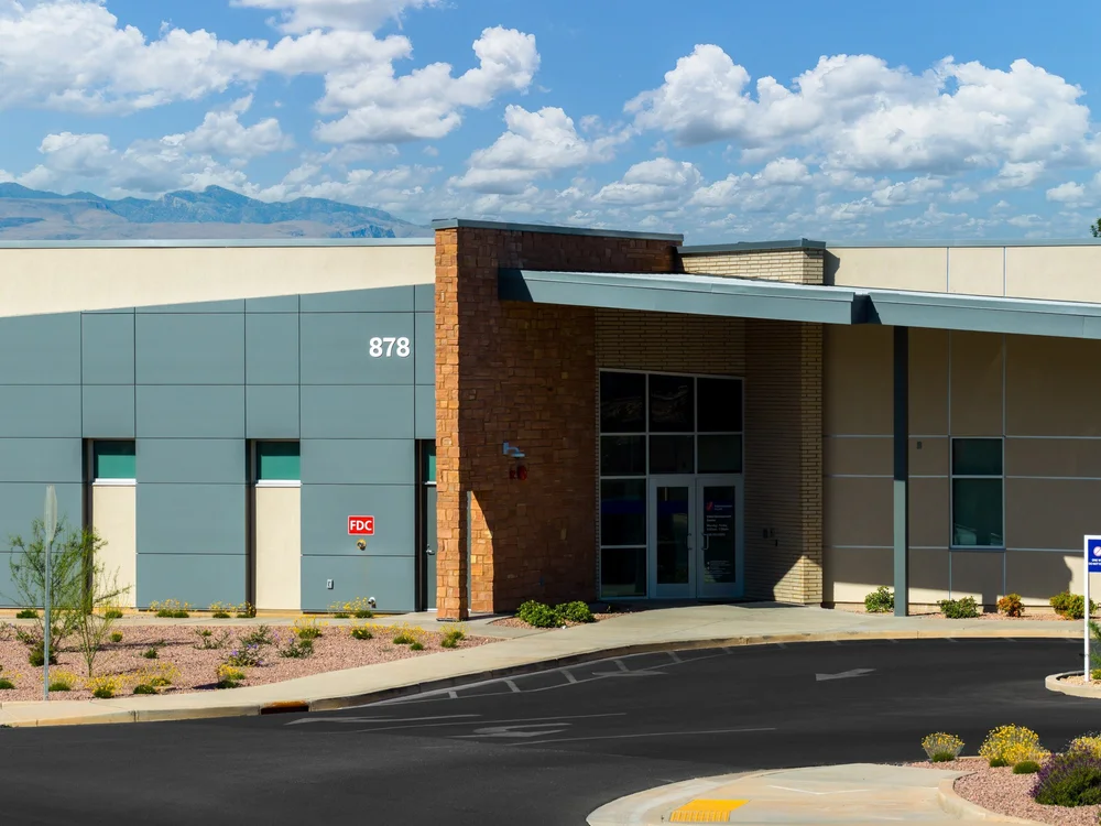 Covered entrance with stone columns and blue-gray wall panels.