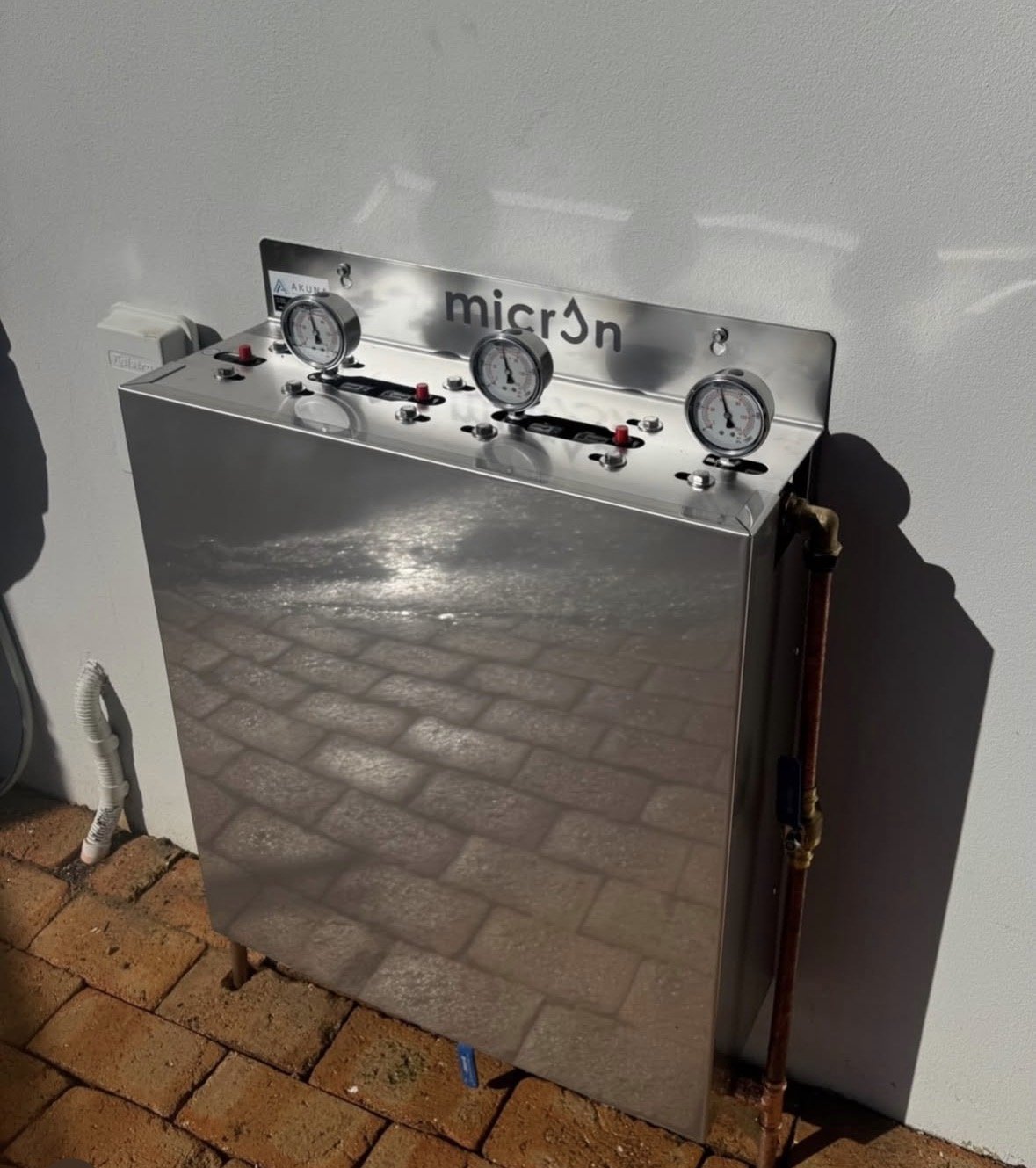 Micron whole-house water filtration installation with stainless steel cover and pressure gauges
