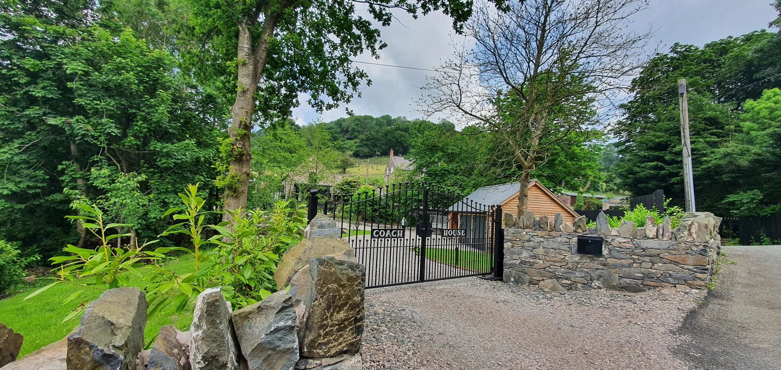 Garden entrance design in St Asaph with timber gates and granite sett paving