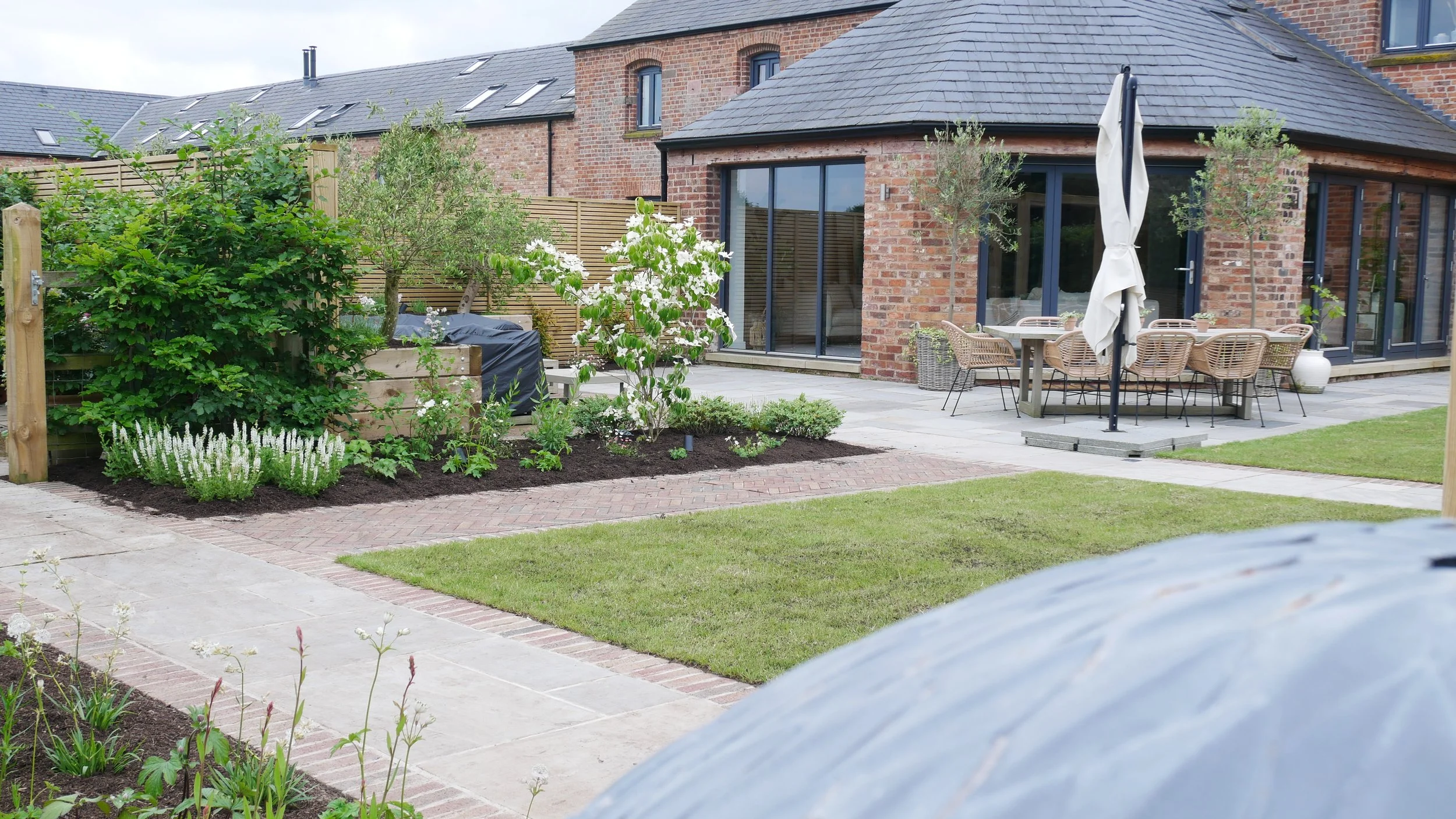 White garden design in Cheshire with restrained planting and soft natural light