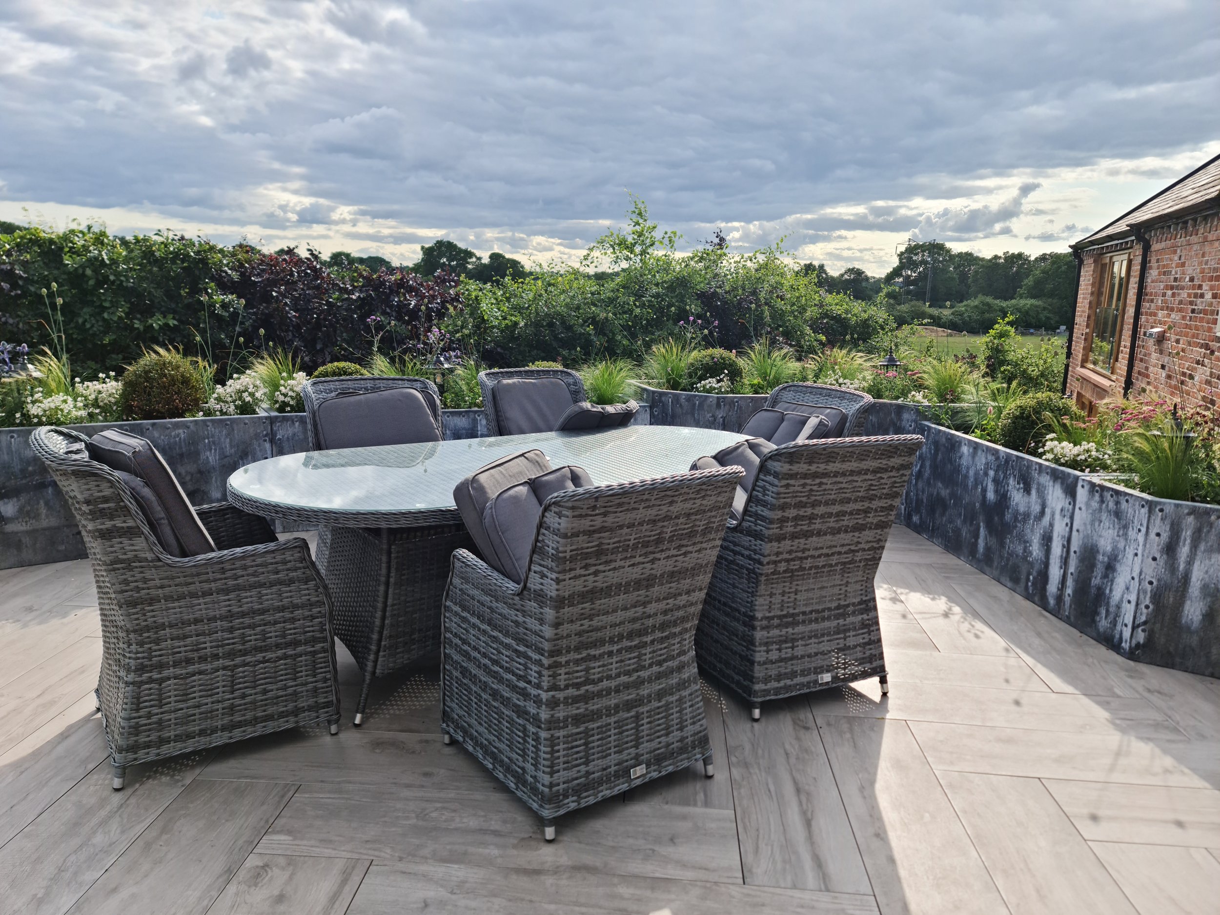Curved planting beds and lawn organised around the windmill