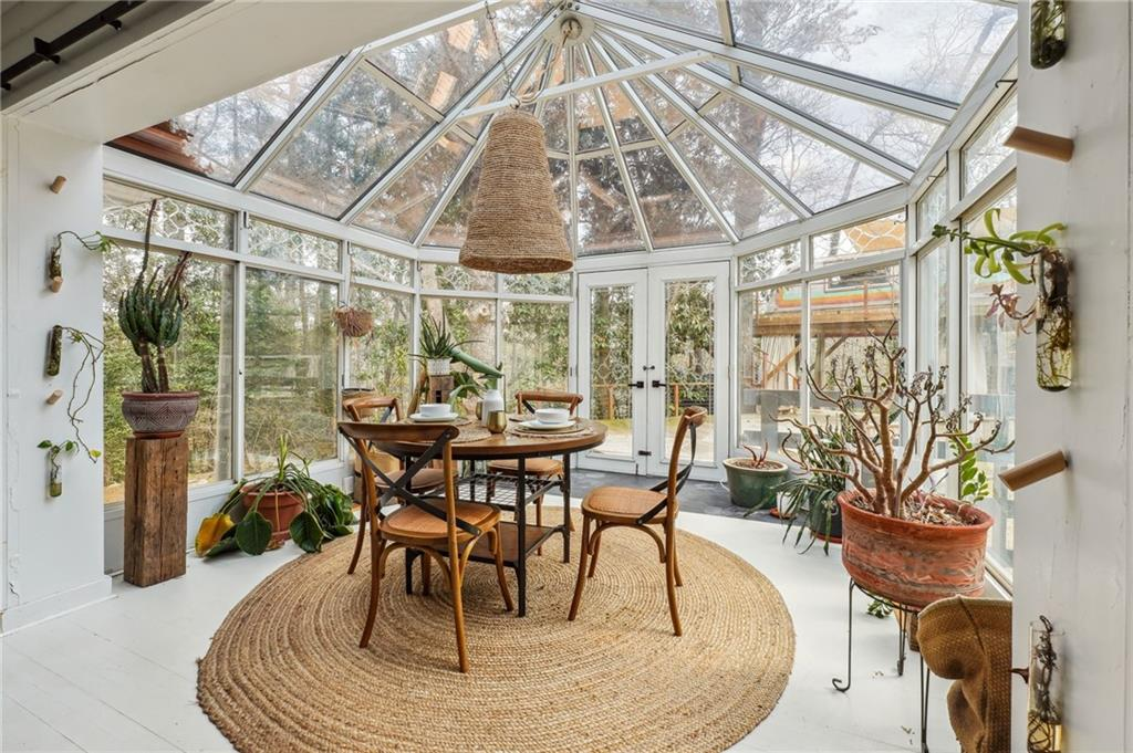 Bright greenhouse-style sunroom with lush plants and natural light