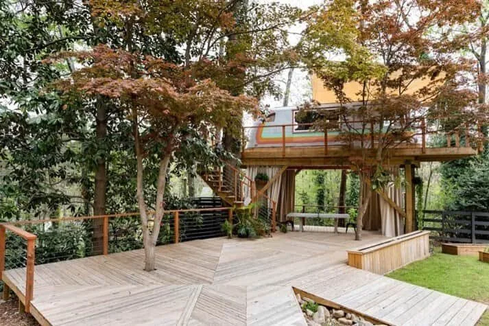 Treehouse deck with outdoor seating and wooded garden views