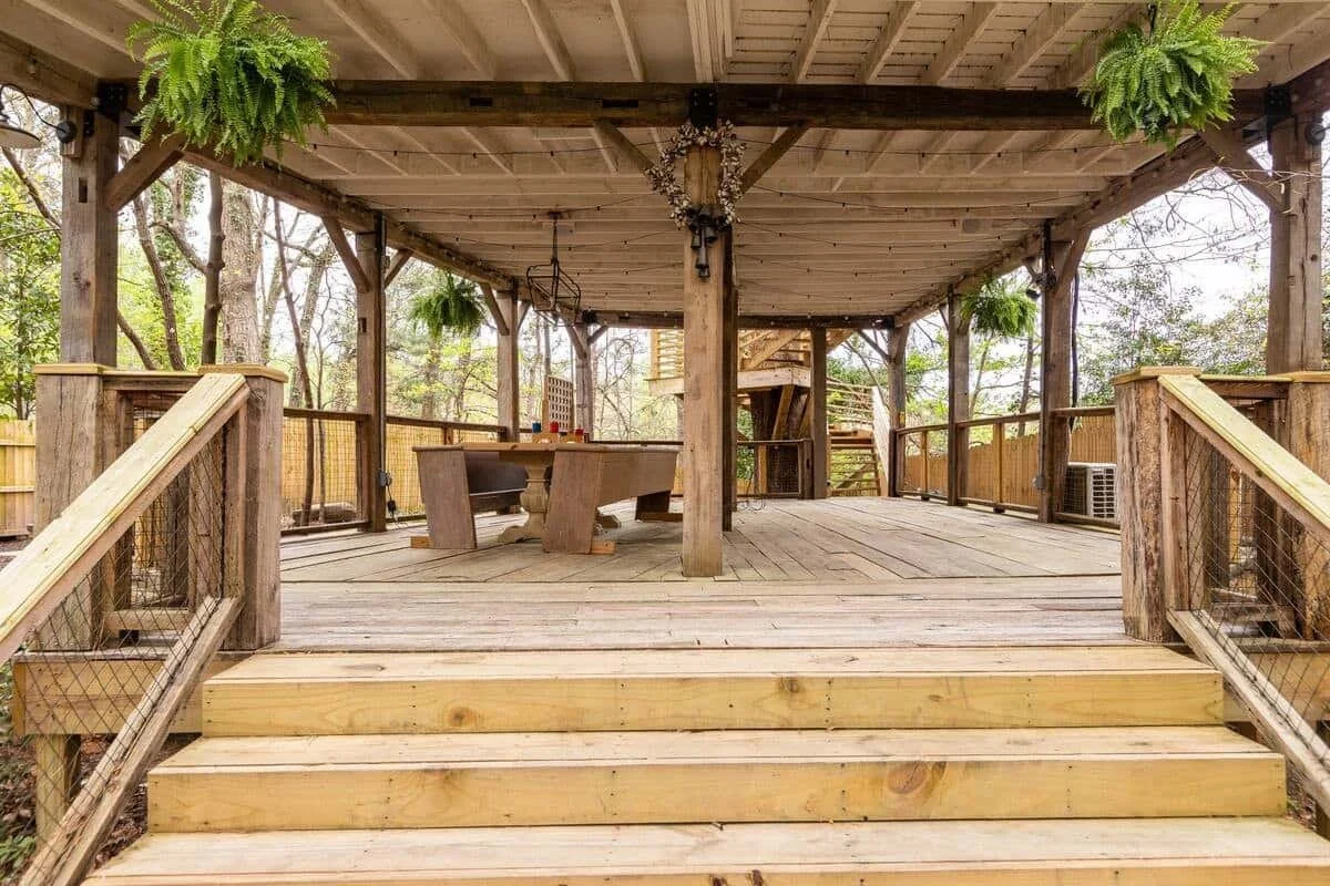 Under-deck patio area with dining table and string lights