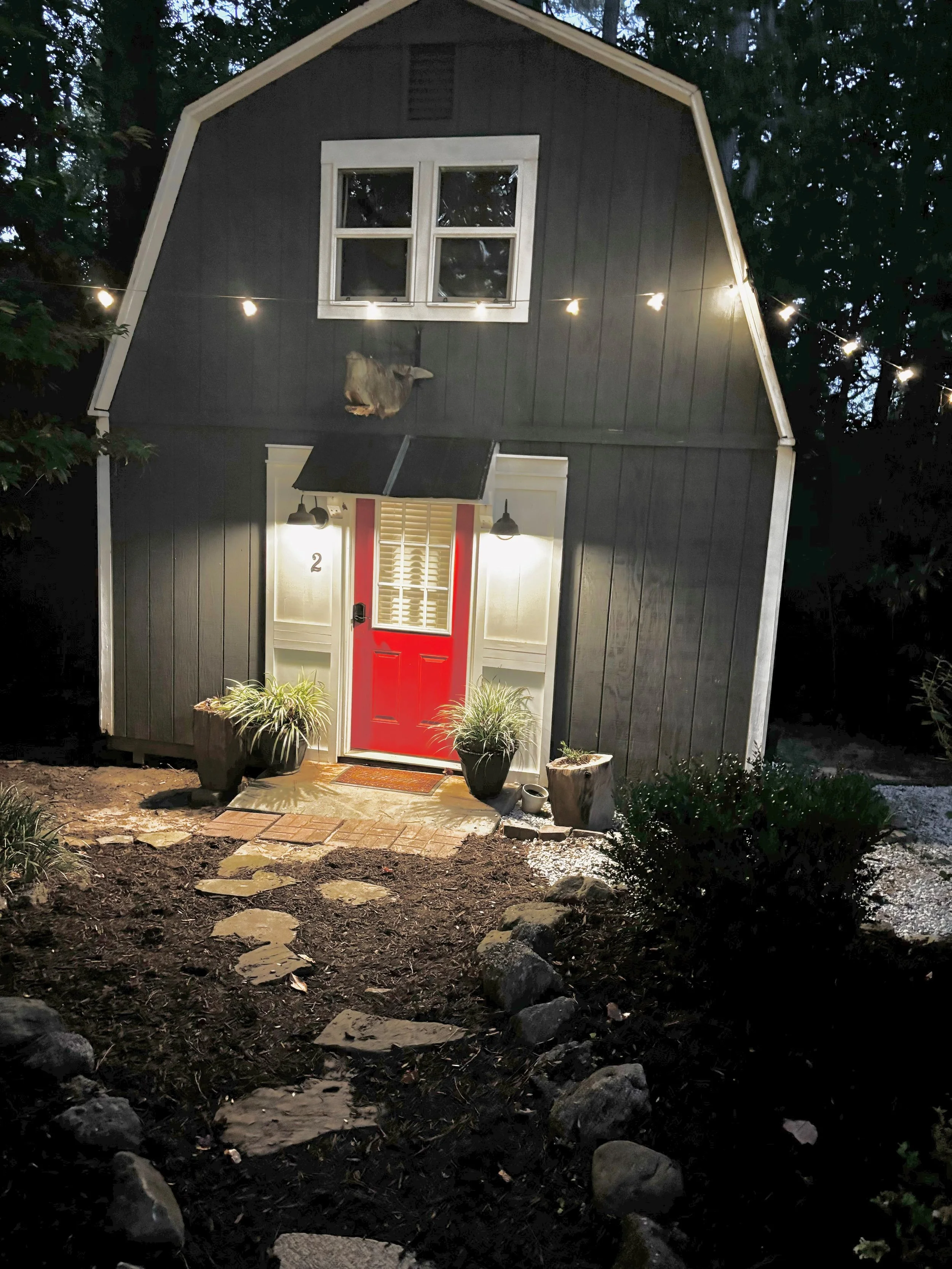 Modern barn escape illuminated at night with fire pit glow